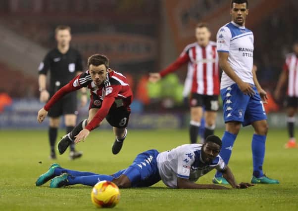 Stefan Scougall of Sheffield United in the air after a challenge from Leon Barnett of Bury