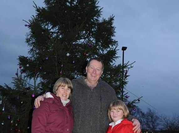 Joanne, Kevin and Claudia Palmer next to the Christmas tree planted on the roundabout in Greenhill