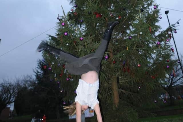 Claudia Palmer celebrates the Christmas tree being put up by doing cartwheels.