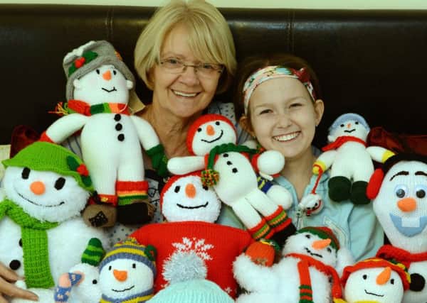 Grandma Carol Connelly with 12 year old Laura Powell and their knitted snowmen that they raffled off to raise over Â£2000