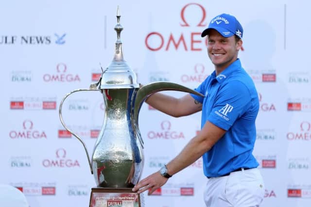 Danny Willett poses with the trophy after he won the Dubai Desert Classic golf tournament in Dubai, United Arab Emirates, Sunday, Feb. 7, 2016. (AP Photo/Kamran Jebreili)