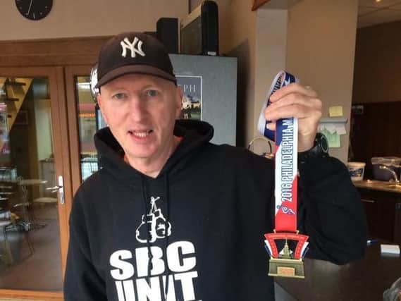 John McCormack with his Philadelphia Marathon finisher's medal.