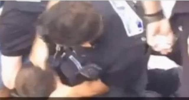 A clip from the video showing a man biting a police officer.