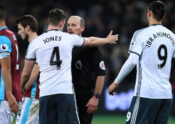 Manchester United's Phil Jones (centre left) complains to referee Mike Dean. Pic John Walton/PA Wire.