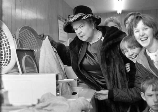 Coronation Street's Ena Sharples, actress Violet Carson, puts the washing in after opening a new laundrette in Lower Ince in 1967.