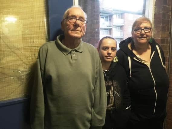 Peter Simpson and Mary Hayball with friend Susan Smith, centre, by the damaged front door of their block of flats in Darnall.