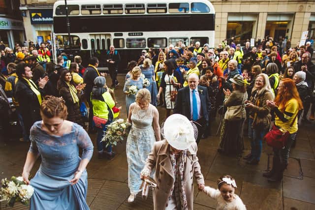 Protesters applaud as the wedding party climbs the steps to Sheffield Town Hall