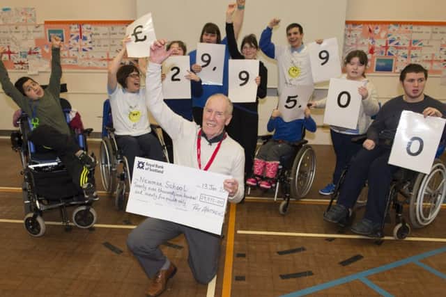 Marathon man Ray Matthews presents a cheque for nearly £30,000 to Newman School in Rotherham