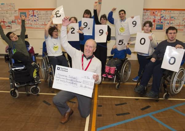 Marathon man Ray Matthews presents a cheque for nearly Â£30,000 to Newman School in Rotherham