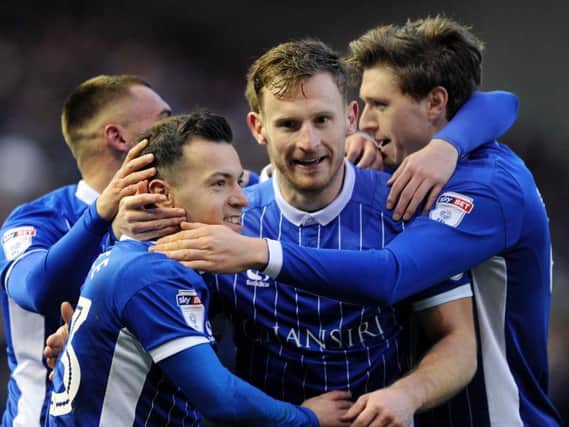 Tom Lees, centre, congratulates Ross Wallace on his goal which opened the scoring against Huddersfield Town on Saturday