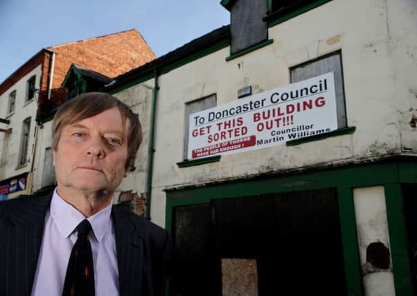 Doncaster Councillor Martin Williams with his banner on the derelict building in Thorne Market Place