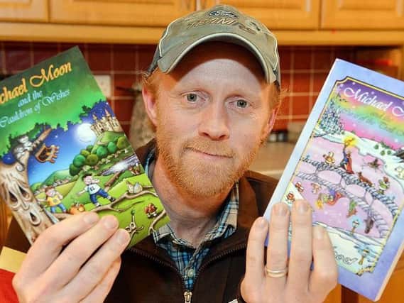 Children's author Dean Wood holding his two Michael Moon books. Picture: Brian Eyre.