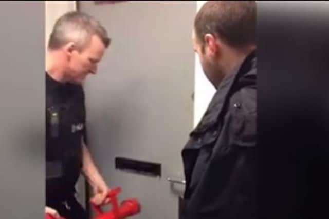 Police officers force their way into a flat in Sheffield