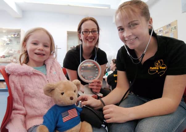 Teddy Bear Hospital. Ester Mead has teddy  bear Freddie's blood pressure checked by  trainee doctors  Helen Hughes and Sarah Ashley  at the Teddy Bear Hospital Day held in  the Weston Park Museum .