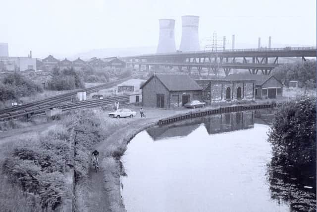 The Sheffield to Tinsley Canal, with the famous cooling towers and road viaduct in the background, showing wharf buildings and a train track. Picture courtesy of John Allchurch