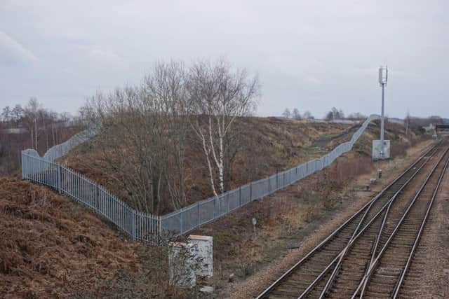 Railway lines run along two sides of the site.