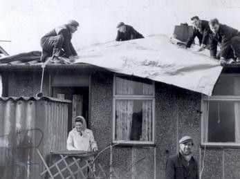 Residents of Skye Edge Avenue get a roof over their heads as workmen lay tarpaulin to protect their hurricane ravaged homes