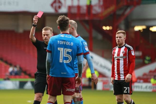 Harry Toffolo of Scunthorpe Utd receives a red card from referee Michael Jones. Simon Bellis/Sportimage