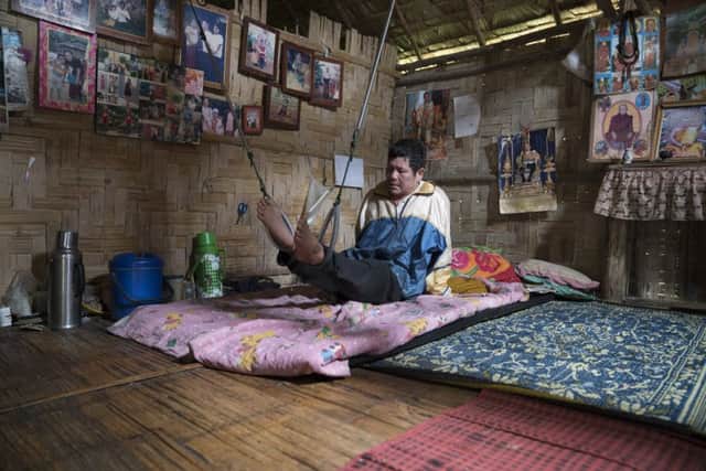 Burmese refugee camps in Thailand. Paralysed Eh Htoo, 59, uses hoops hanging from the ceiling of his home in Umpiem Mai camp to exercise his legs.

Photo: Matt Gonzalez-Noda