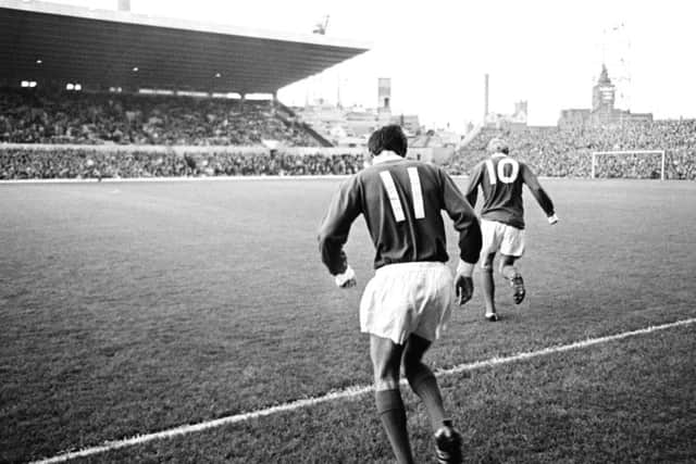 George Best of Manchester United (11) runs onto the pitch, following Denis Law (10) at Old Trafford, circa 1964.