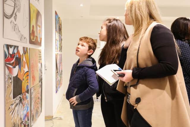 Guests admire the works at the exhibition.