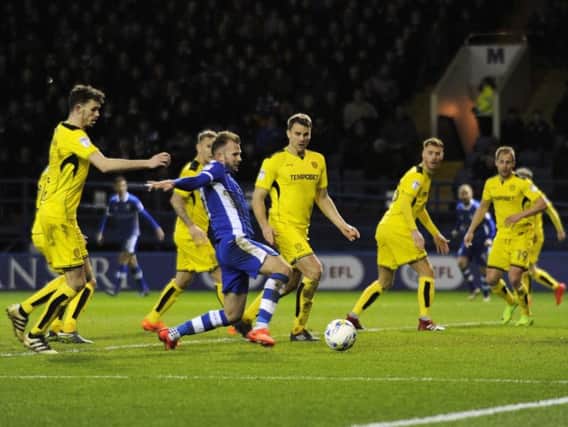 Sheffield Wednesday striker Jordan Rhodes attempts a shot, surrounded by Burton Albion players