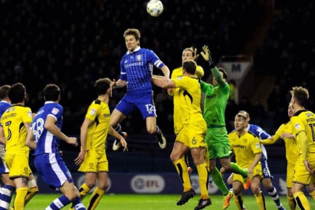 Glenn Loovens rises for a header surrounded by Burton players