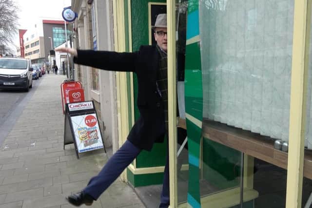 Doing a Harry Worth...Jack Land Noble performing the 'miraculous levitation' in a Barnsley shop window.