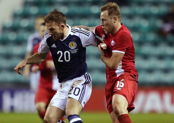 Scotland's Jordan Rhodes (left) and Canada's Scott Arfield battle for the ball during the International Friendly match at Easter Road
