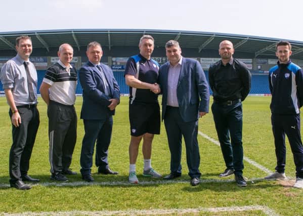 Chesterfield FC academy manager Mark Smith and CEO of the Spireites Community Trust John Croot shake hands to launch the club's new Emergine Talent Centre alongside club and trust staff and scheme partners
