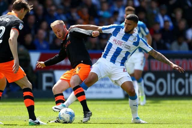 Sheffield Wednesday's Barry Bannan (centre) and Huddersfield Town's Nahki Wells (right) battle for the ball during the Sky Bet Championship Play Off, First Leg match at the John Smith's Stadium, Huddersfield. PRESS ASSOCIATION Photo.