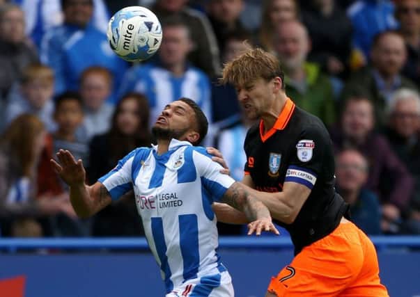Huddersfield Town's Nahki Wells (left) and Sheffield Wednesday's Glenn Loovens battle for the ball during the Sky Bet Championship Play Off, First Leg match at the John Smith's Stadium