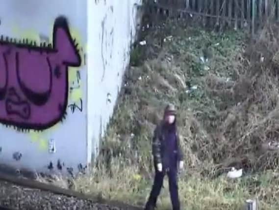 CCTV caught this woman trespassing on the railway line.