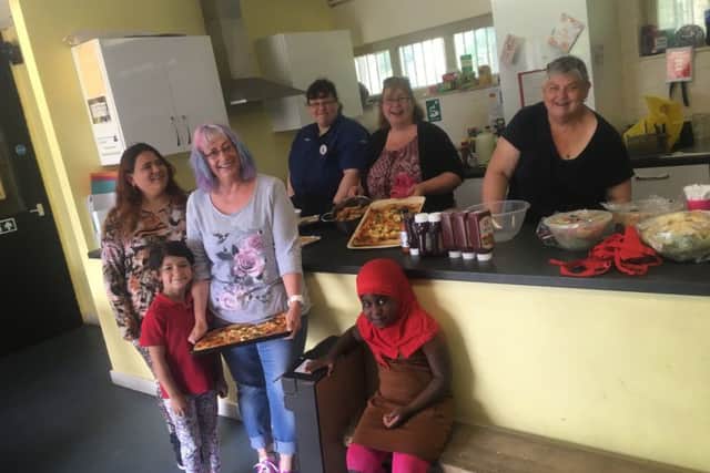 Sarah Kesteven shares her puff pastry pizza with neighbours who she now considers friends at a barbecue held as part of the Know Your Neighbour campaign at Pitsmoor Adventure Playground.