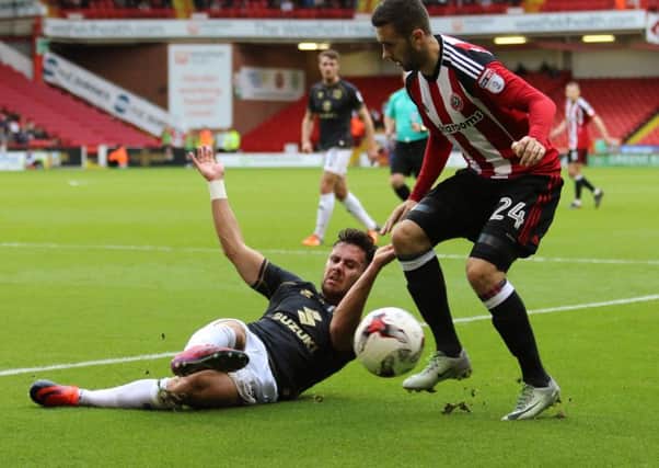 George Baldock of MK Dons slides towards Daniel Lafferty of Sheffield United. Pic Jamie Tyerman/Sportimage