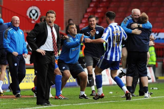Sheffield Wednesday's Gary Madine celebrates with the bench after scoring his side's second goal as Sheffield United manager Danny Wilson looks on at Bramall Lane, Sheffield.  October 16, 2011.
