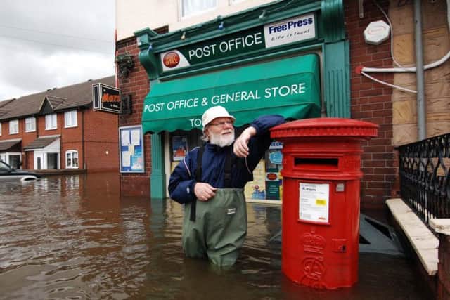 Post master John Jackson stands outside his flooded shop at Toll Bar, Doncaster