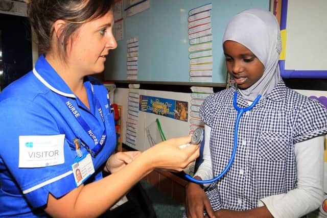 Pictured is district nurse Kate Coyle with Hindiyo Ali Hibrahim, eight.