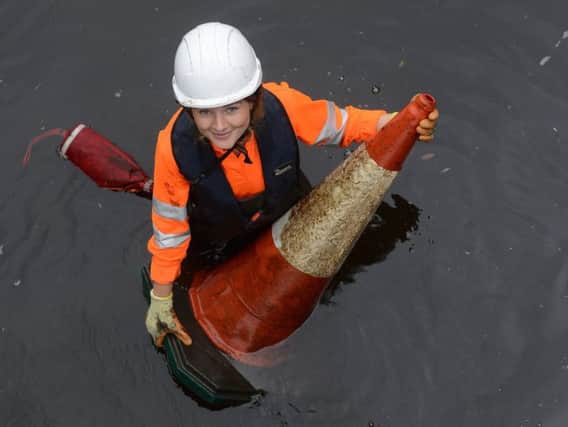 Rochelle Kent-Ellis removes a traffic cone from the River Don in Sheffield (Scott Merrylees)