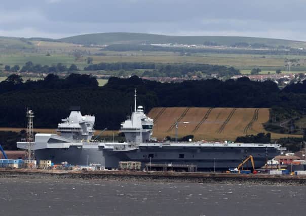 HMS Queen Elizabeth, one of two new aircraft carriers for the Royal Navy sits docked in the sunshine at Rosyth dockyard near Edinburgh ahead of her sea trials which are due to begin. Picture: Andrew Milligan/PA Wire