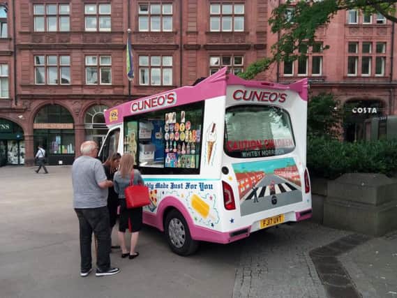 Customers queue for an ice cream from the Cuneo's van at the Peace Gardens