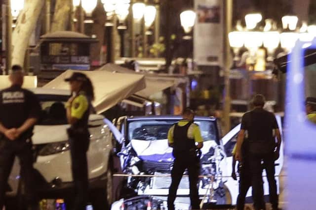 Police officers stand next to the van involved on an attack in Las Ramblas, Barcelona. Picture: AP