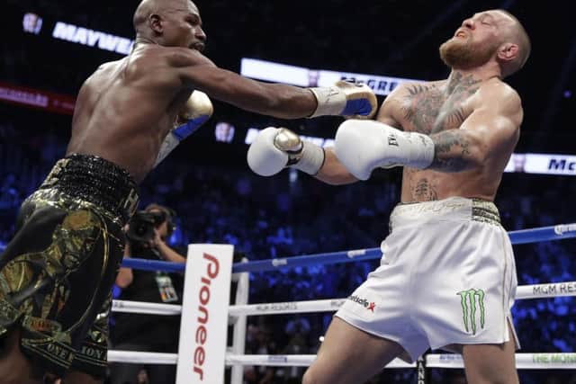 Mayweather lands a punch of McGregor. (AP Photo/Isaac Brekken)