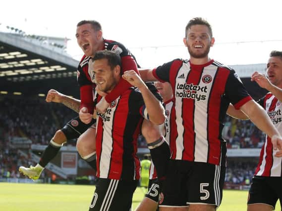 Billy Sharp of Sheffield Utd celebrates with the help of John Fleck and Jack O'Connell of Sheffield Utd during the Championship match at Bramall Lane, Sheffield - Simon Bellis/Sportimage