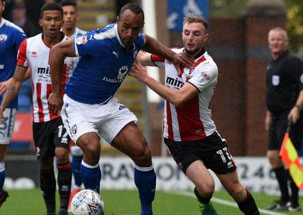 Chesterfield's Chris O'Grady fends off Cheltenham's Carl Winchester. Photo: Andy Roe.