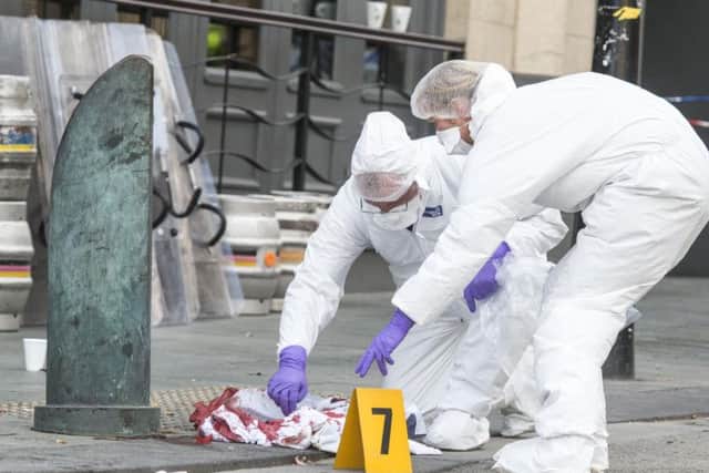 Police CSI officers inspect blood stained clothes outside Yates's in Barkers Pool in Sheffield