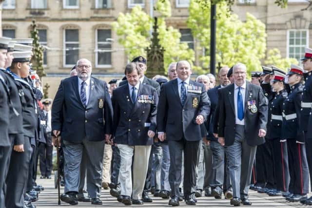 Survivors from the HMS Sheffield make their way through a guard of honour during a memorial service in the city