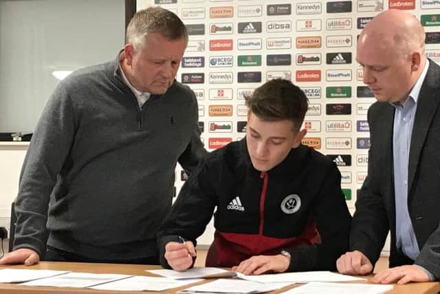 David Brooks signs new deal, watched by Blades boss Chris Wilder.