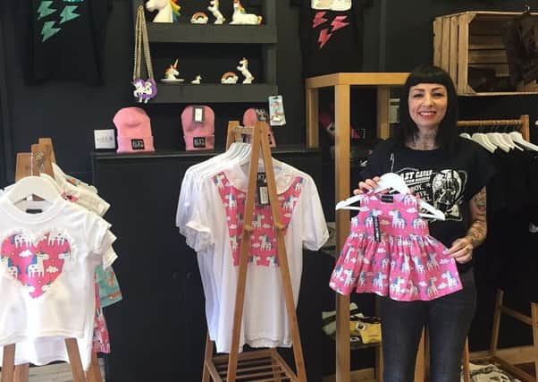 Claire Middleton holds up some of her unique, alternative fashion designs in her Rotherham boutique store Boneyard & Co.
