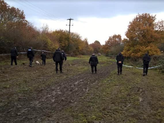 Police officers searching an are of land in Bentley